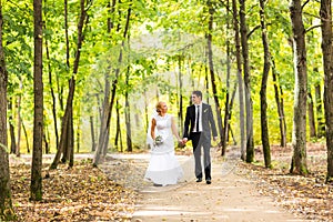 Bride and groom holding hands outdoors