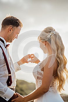 Bride and groom holding hands to heart