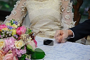 Bride and groom holding hands with a wedding ring box.