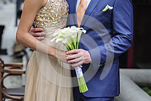 Bride and groom holding a wedding bouquet of callas