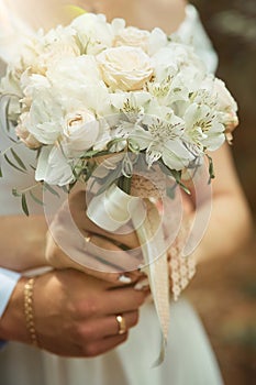 the bride and groom hug each other and hold a wedding bouquet.