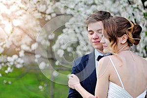 Bride and groom hugging in the flowered Spring Garden wedding walk