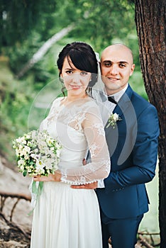 The bride and groom hugging in the forest