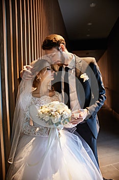 Bride and groom hugging and kissing while standing on the stairs. Wedding, gentle embrace of man and woman
