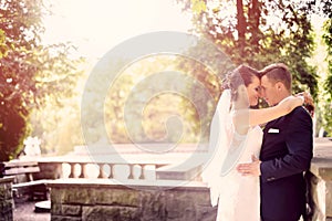 Bride and groom hugging in the park.