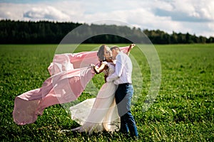The bride and groom kiss in the field