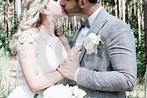 The bride and groom kiss in the forest at the wedding ceremony. selective focus.