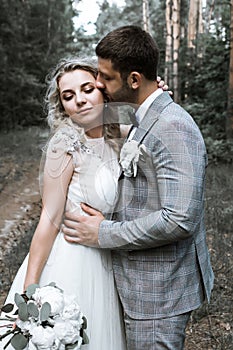 The bride and groom kiss in the forest at the wedding ceremony. selective focus.