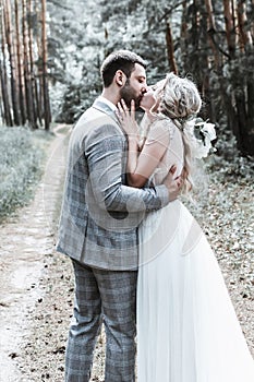 The bride and groom kiss in the forest at the wedding ceremony. selective focus.