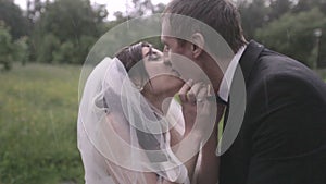 Bride and groom kiss in the rain on their wedding day