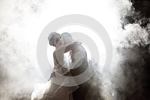 Bride and Groom kissing in fog at night