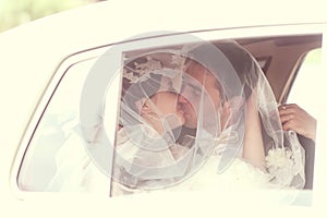 Bride and groom kissing in a retro car