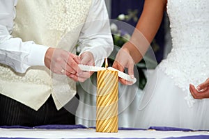 Bride and groom light the wedding candle at the ceremony