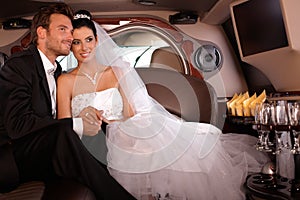 Bride and groom in limo smiling