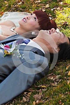 Bride and groom lying on ground