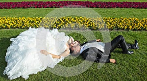 Bride and groom lying on lawn