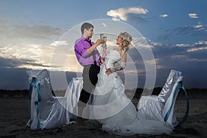 Bride and groom making at sunset