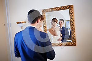 Bride and groom by the mirrir