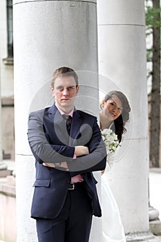 Bride and groom near columns in park