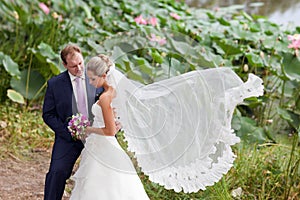 Bride and groom near lotos pond