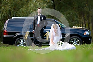 Bride and groom next to wedding car