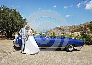 Bride and Groom next to wedding car