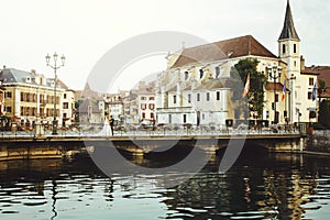 Bride and groom on old romantic bridge over river and church in