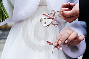 Bride and groom with padlock of love with keys