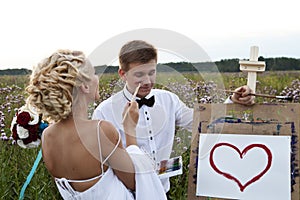 The bride and groom paint on an easel emotion