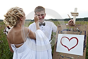 The bride and groom paint on an easel emotion