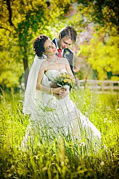 Bride and groom in a park kissing