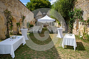 Bride and groom place in summer wedding tent decorated for secular wedding ceremony garden