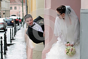 Bride and groom playing hide and seek