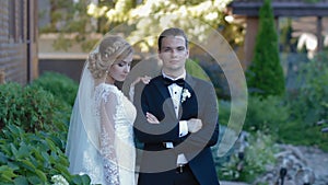 Bride and groom pose to photographer outdoor