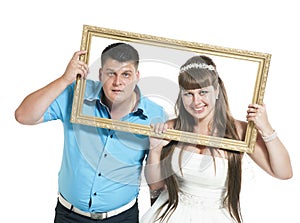 Bride and groom are posing with the big frame