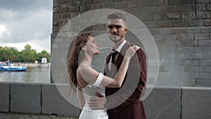 A bride and groom are posing for a picture in front of a brick building