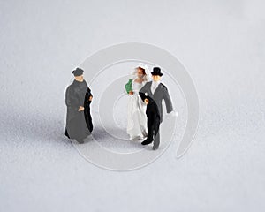 Bride, groom and priest on white