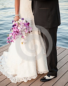 Bride & Groom purple bouquet, black and white spats on the lake dock