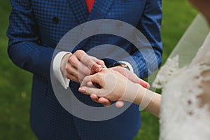 Bride and groom put on the finger a wedding ring.