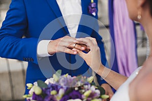 Bride and groom put on the finger a wedding ring.