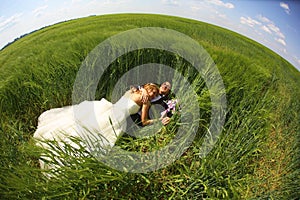 Bride and groom relaxing on the fields