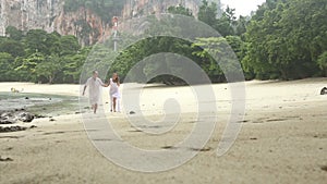 Bride and Groom Run along Beach under Rain