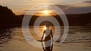 Bride and groom are running across field to a beautiful sunset, slow motion shooting