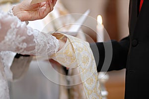 Bride and groom's hands and priest's cassock