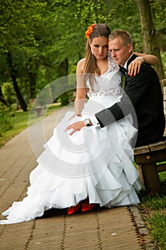 Bride and groom seated in park