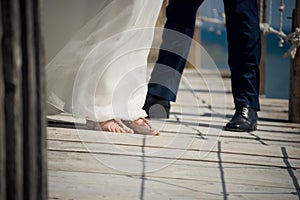 The bride and groom show off their shoes on the pier at this out