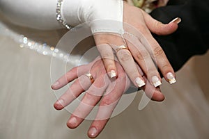 Bride and groom show their hands wearing wedding rings