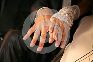 Bride and groom show their hands wearing wedding rings