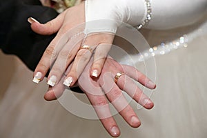 Bride and groom show their hands wearing wedding rings