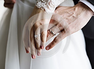 Bride and Groom Showing Their Engagement Wedding Rings on Hands photo